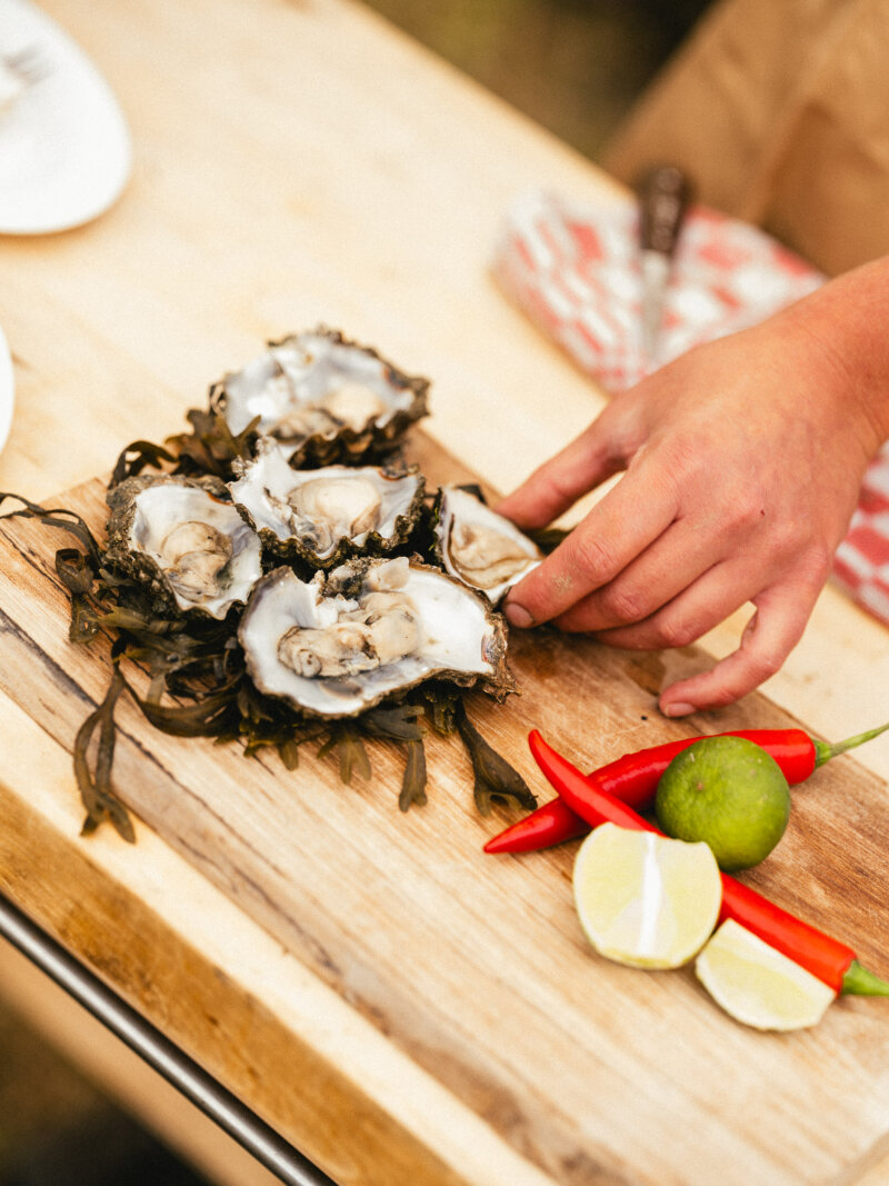 oesters die gepakt worden met pepers en partjes limoen ernaast.