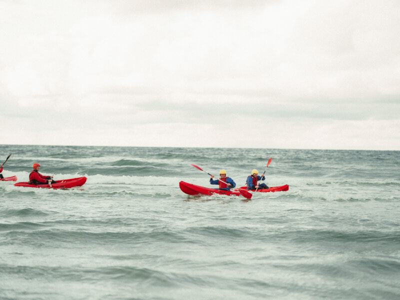 een groep kayakkers in de zee.